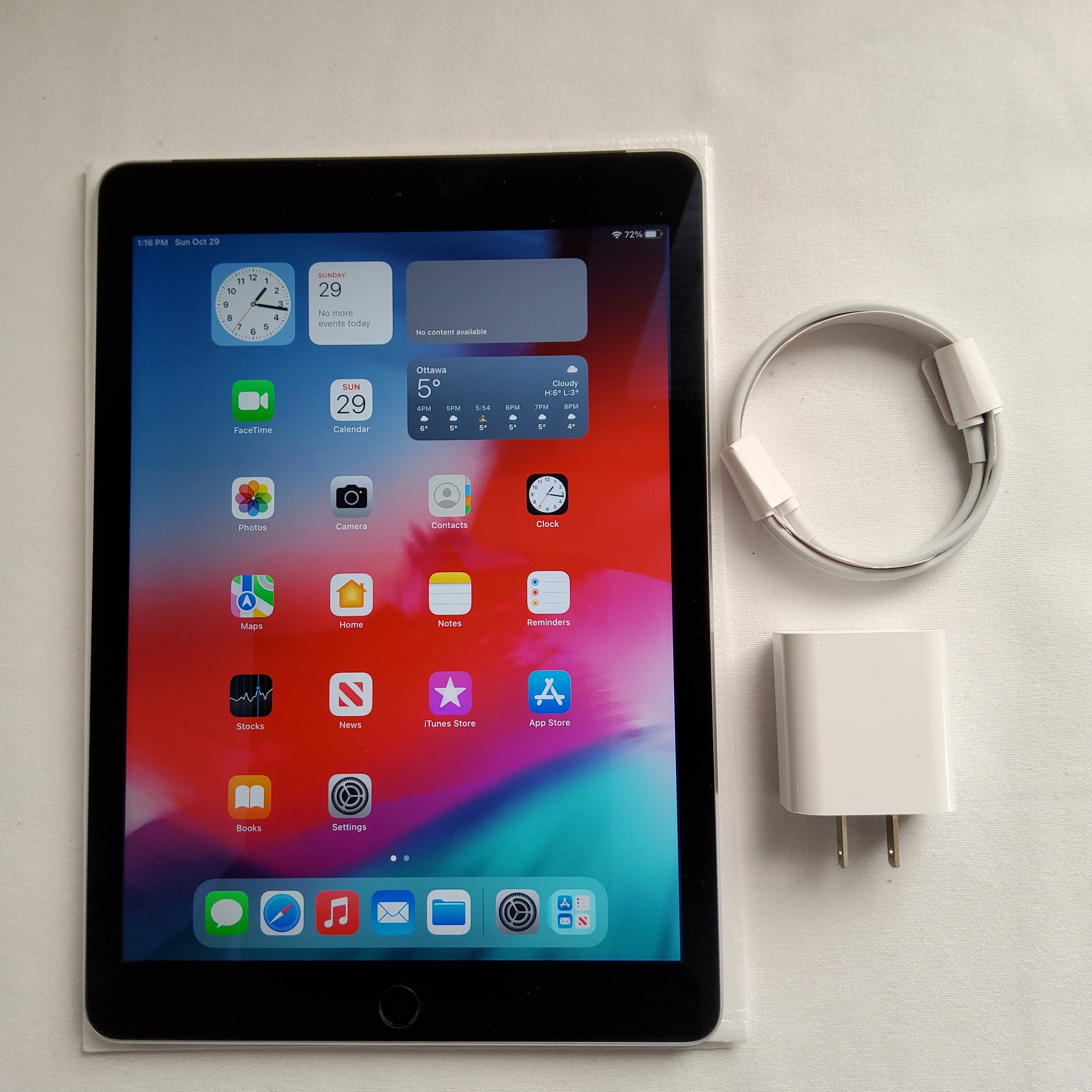 Authentic picture of  Black iPad Air 2 with its charger and cable next to it